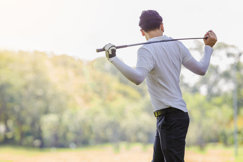 Asian,Couple,Playing,Golf.,Man,Teaching,Woman,To,Warm,Up
